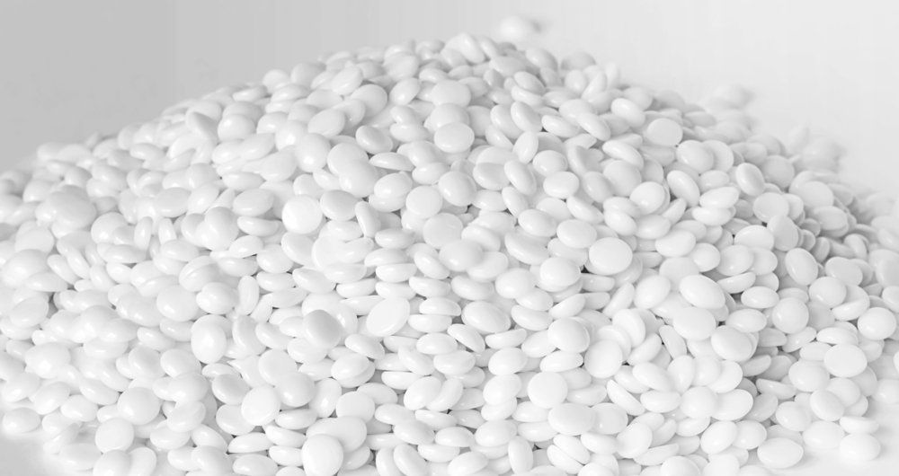 A pile of white beads on a white surface.