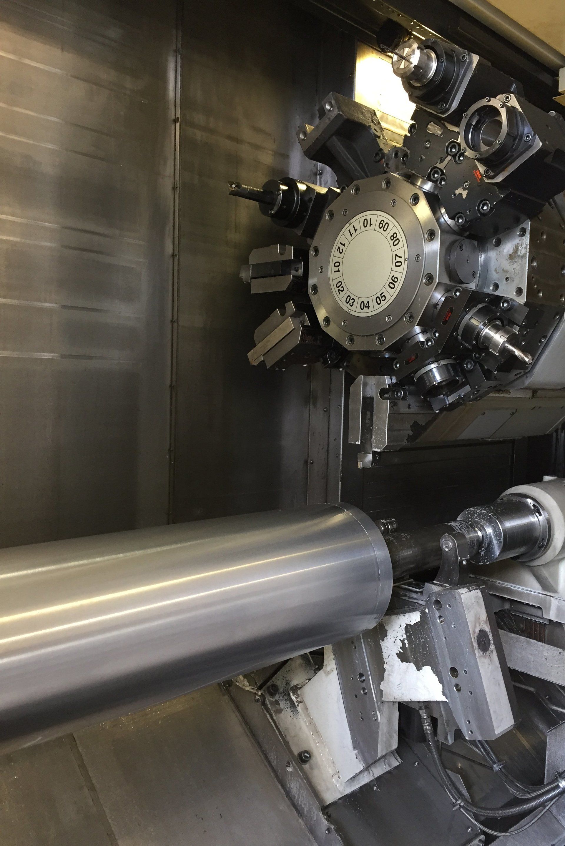 A machine is cutting a piece of metal on a lathe.