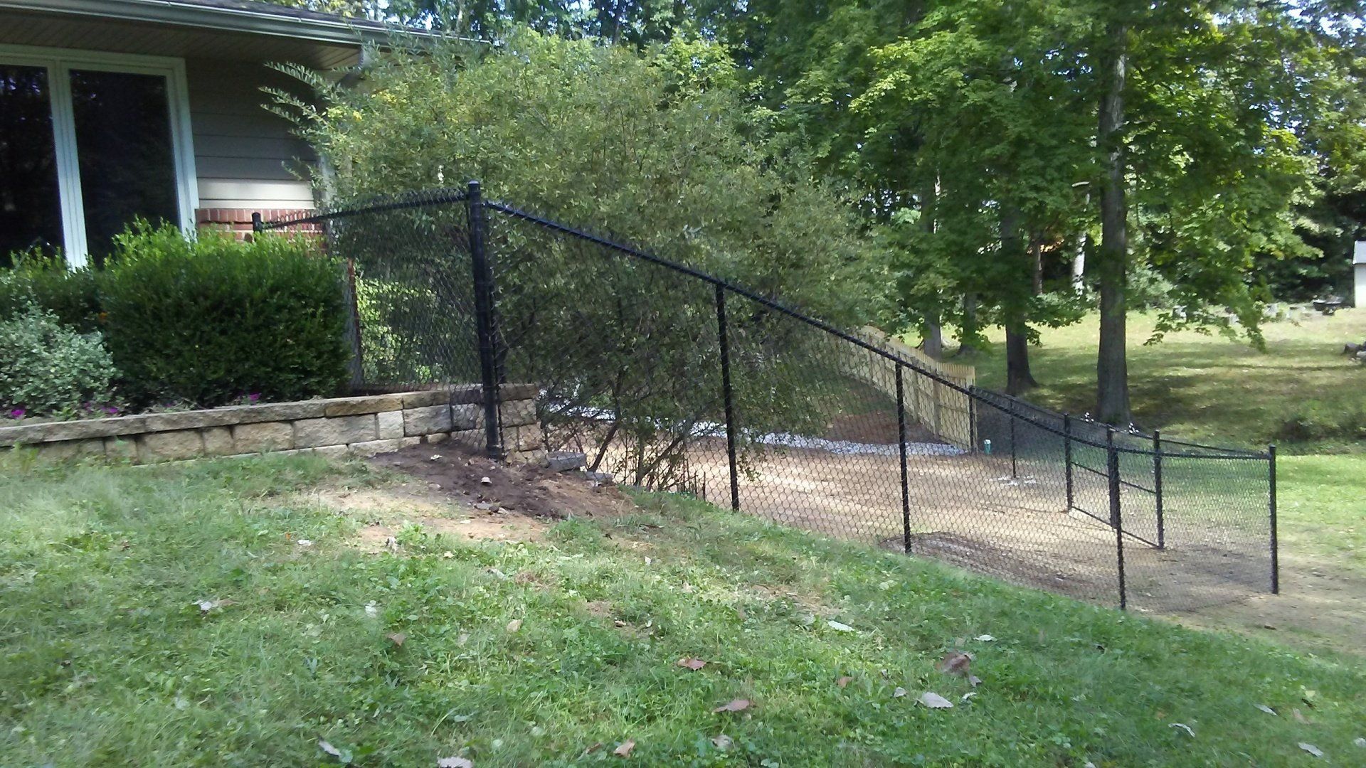 A black chain link fence is in front of a house.