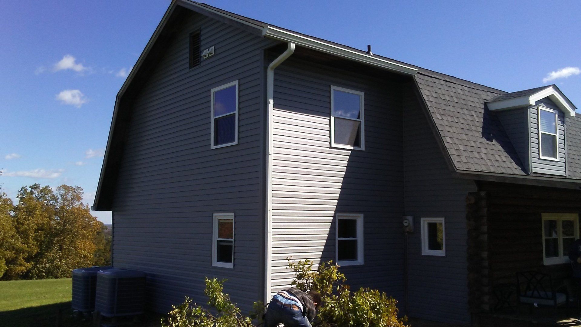 A gray house with white siding and a gray roof