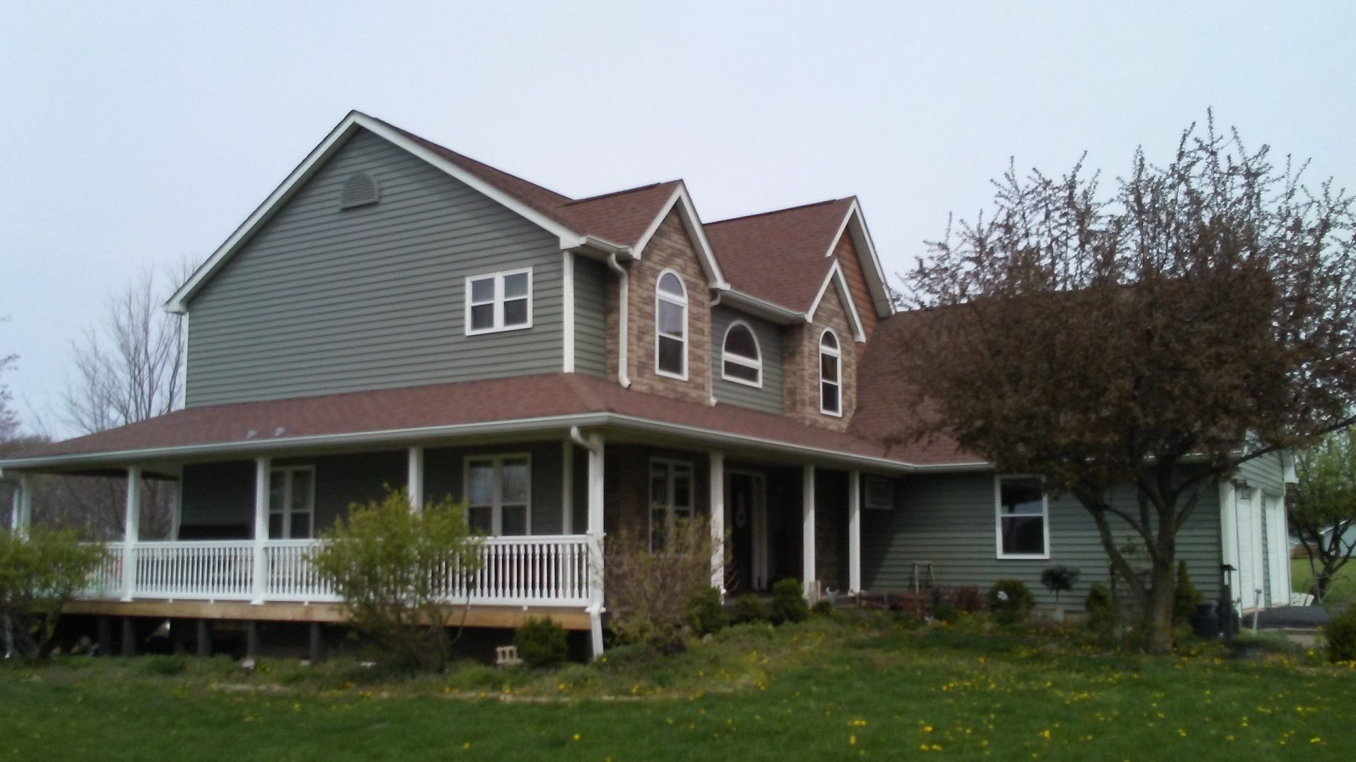 A large house with a porch and a red roof