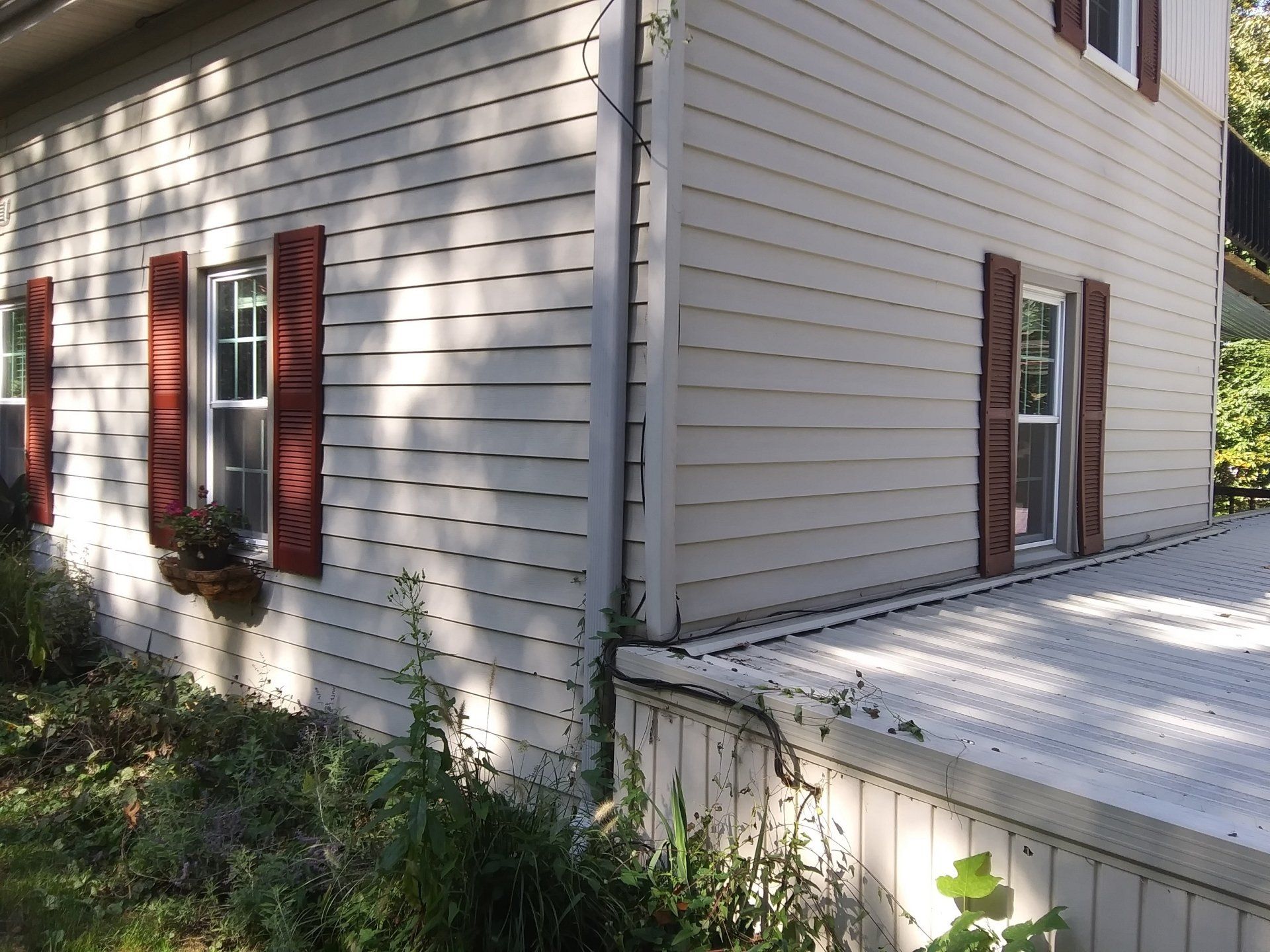 A white house with red shutters on the windows