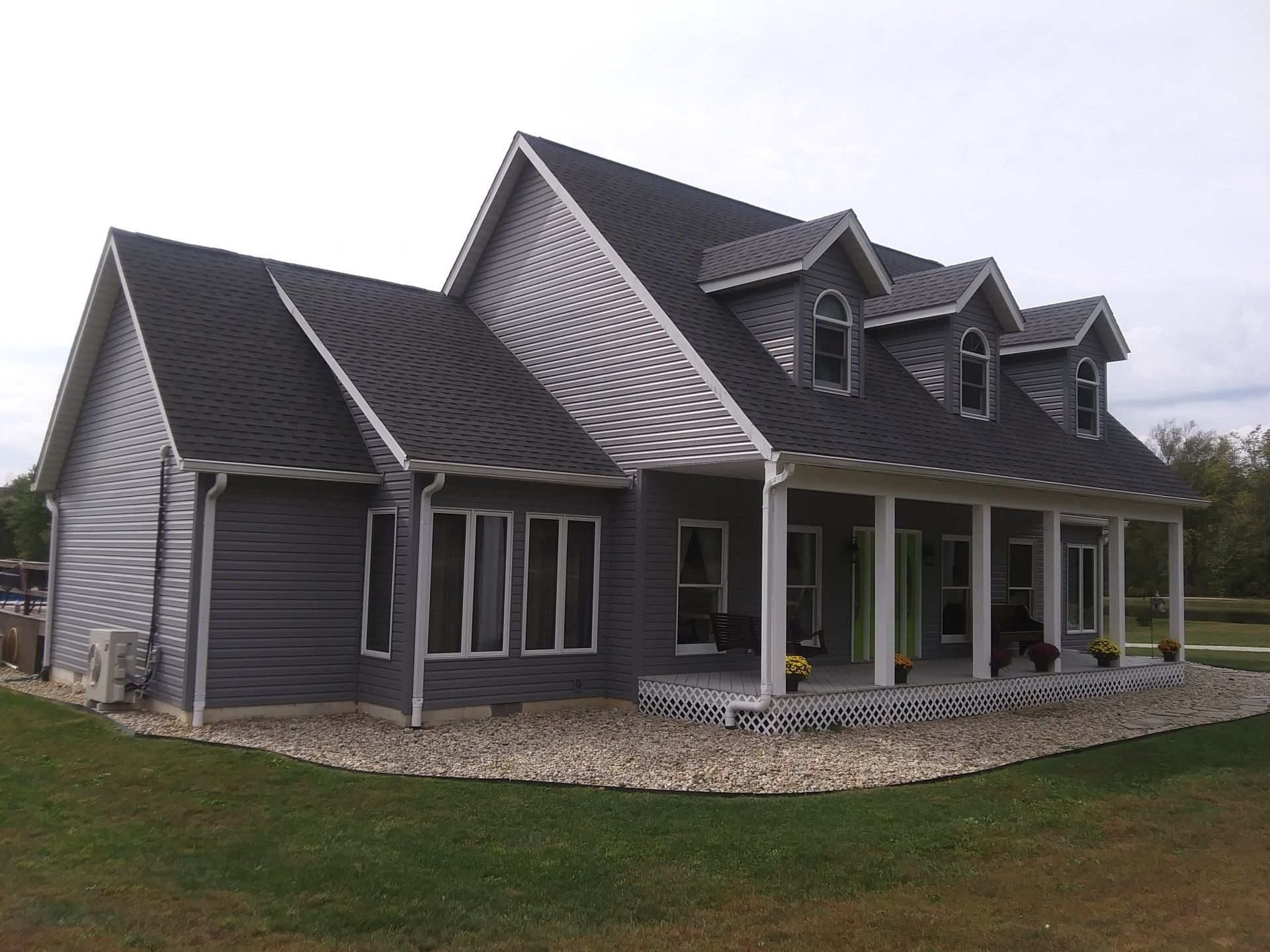 A large house with a porch and a gray roof
