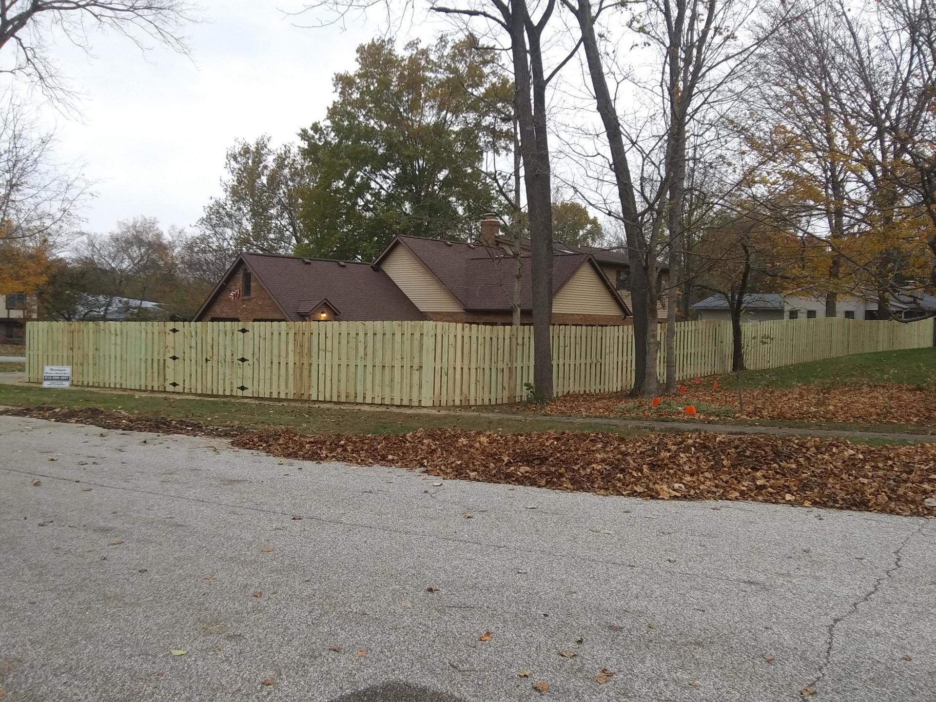 A house with a wooden fence surrounding it