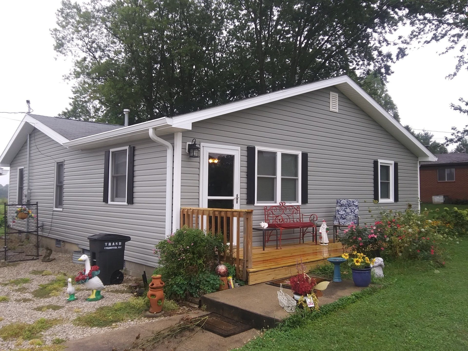 A house with a porch and a bench in front of it.