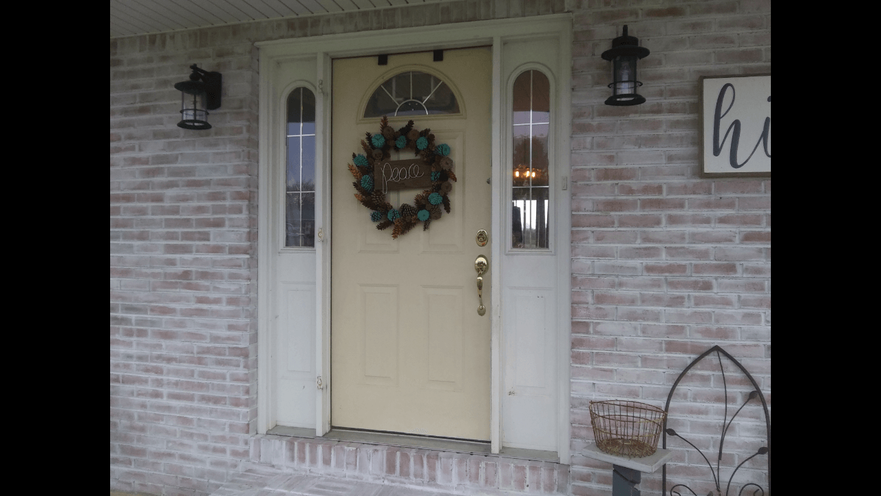 The front door of a house with a wreath on it.