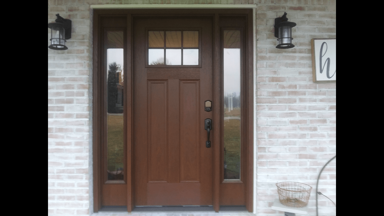A brown front door is on a white brick house.