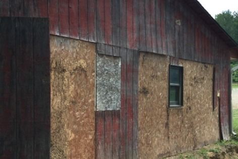 A wooden building with a window and a broken window