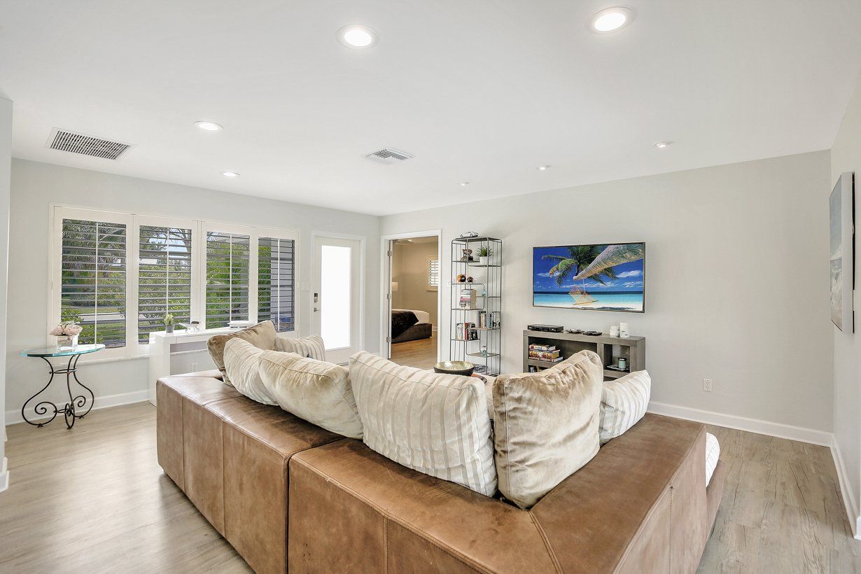A living room with a couch and a television on the wall.