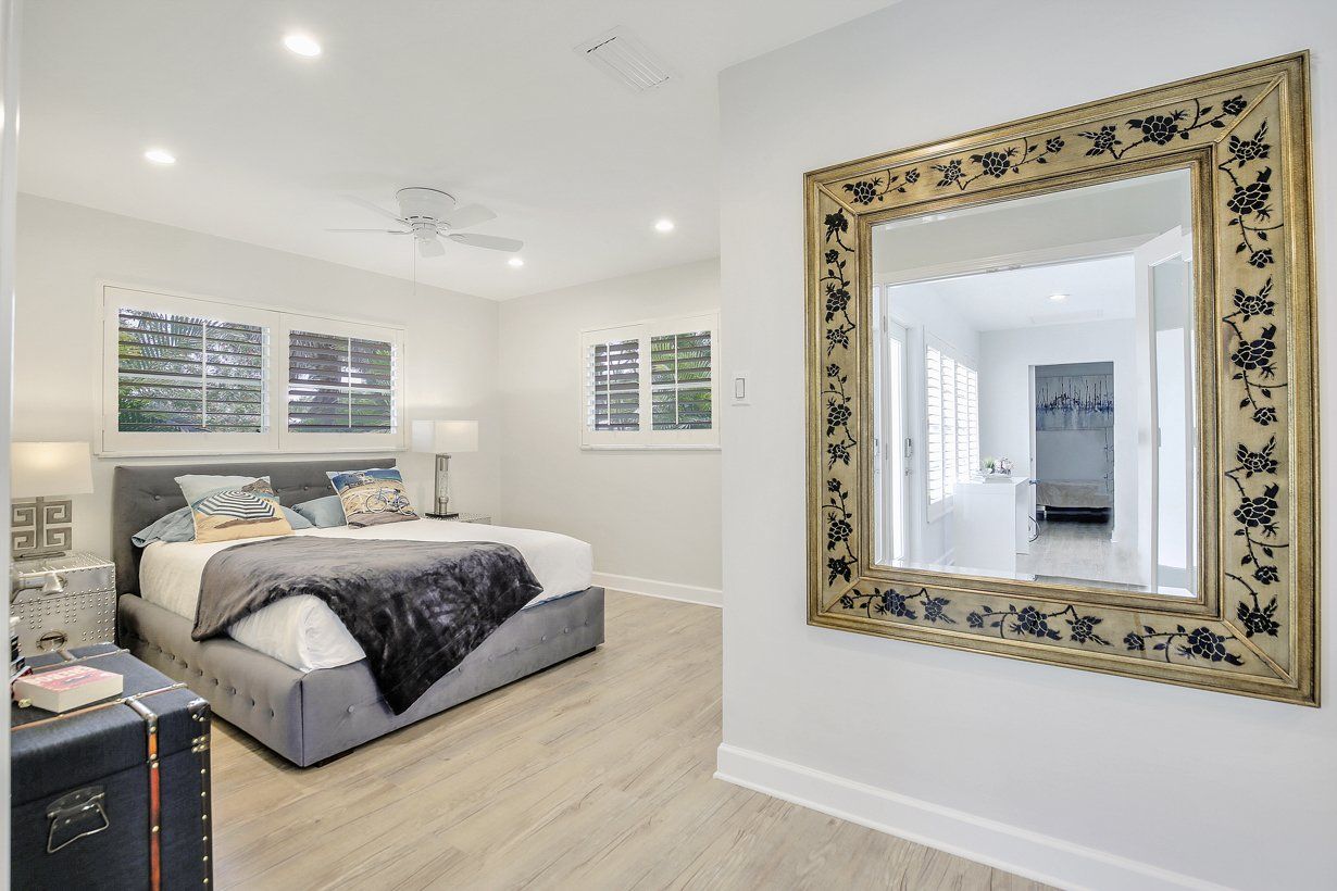 A bedroom with a large mirror on the wall above the bed.