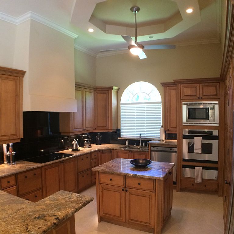 A kitchen with wooden cabinets and granite counter tops