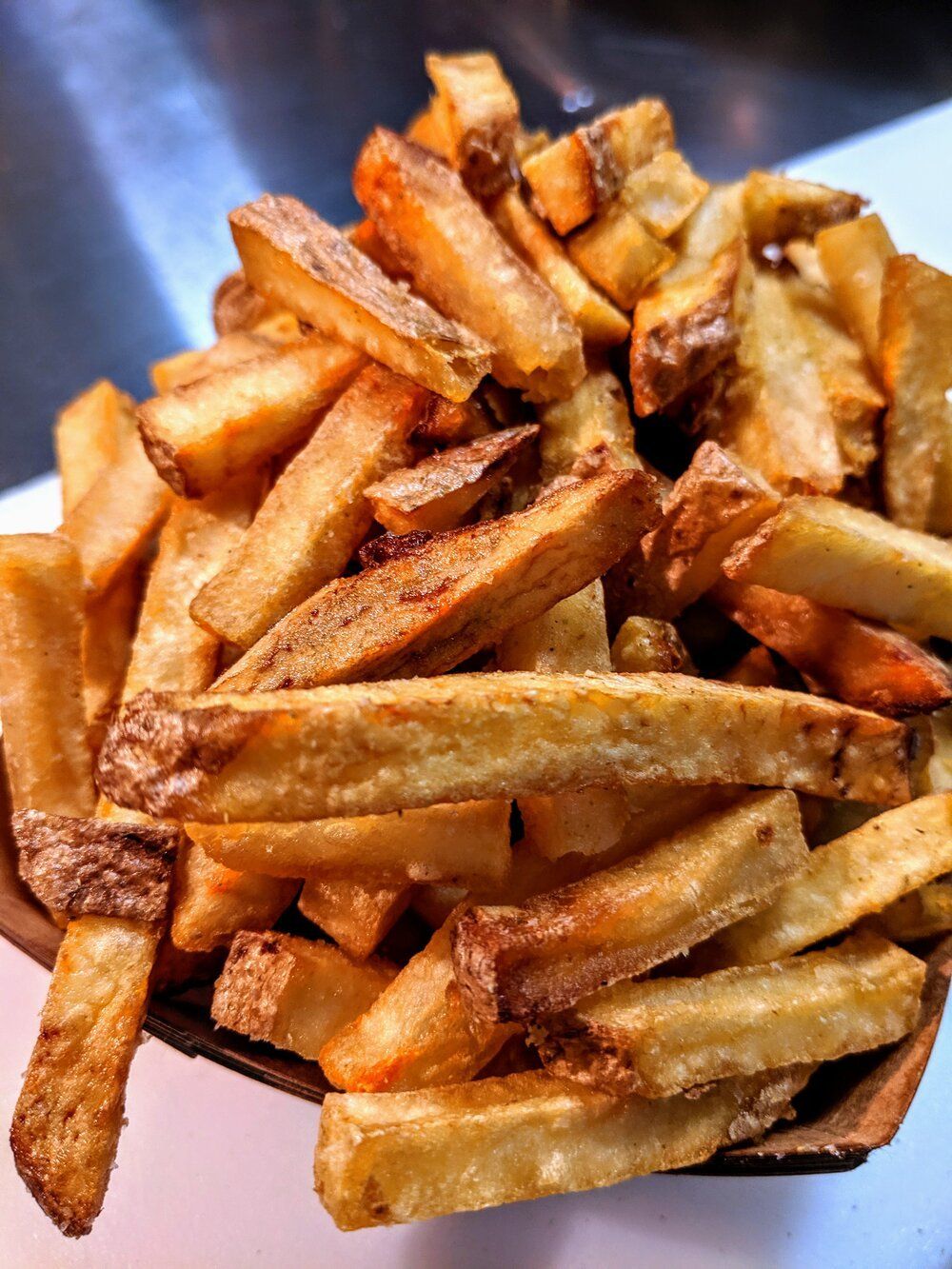 Golden, crispy French fries piled in a small container.