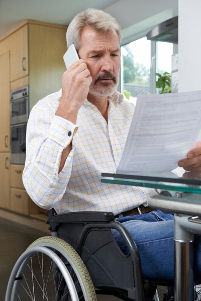 Frustrated Man In Wheelchair Making Phone — Troy, OH — Shipman Dixon & Livingston Lpa Attorneys at Law Frustrated Man In Wheelchair Making Phone — Troy, Oh — Shipman Dixon & Livingston Lpa Attorneys at Law