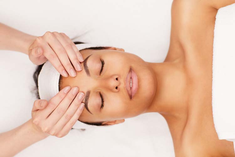 Above view portrait of beautiful woman enjoying face massage in luxury spa