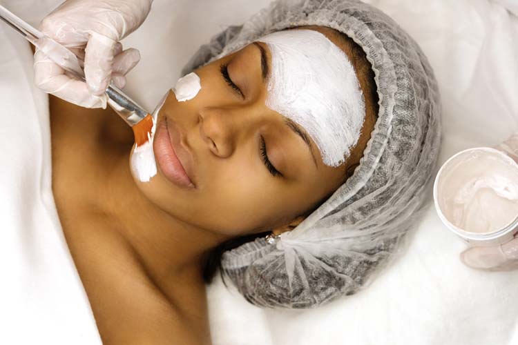 Application of a cosmetology mask on the face of a young woman