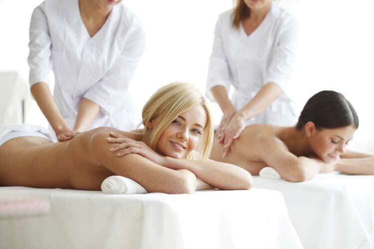 Pretty female friends getting massages together in the health spa