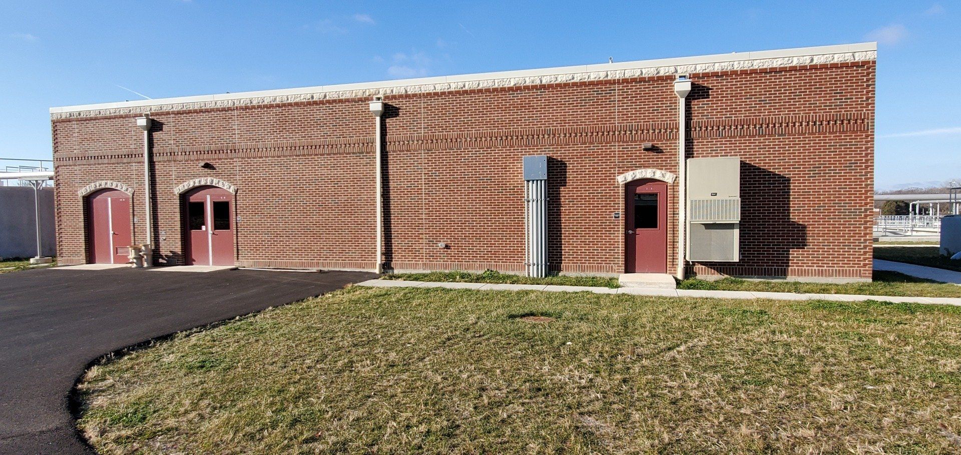 A large brick building with a lot of grass in front of it.