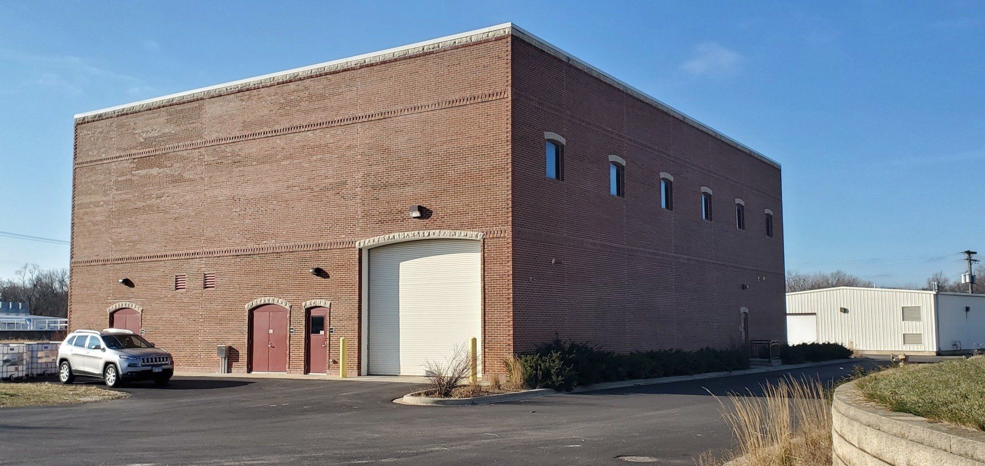 A brick building with a white car parked in front of it.