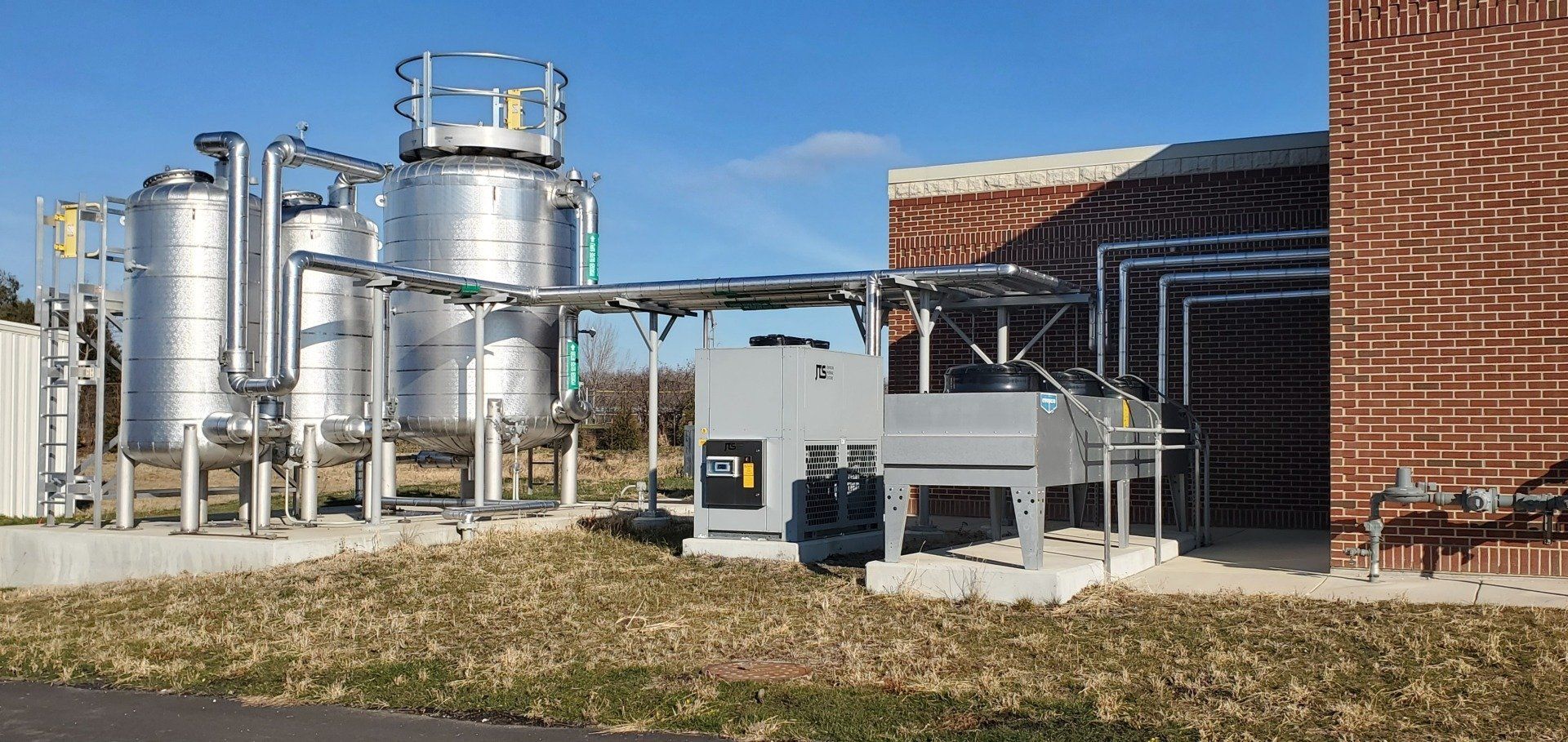 A brick building with a lot of pipes and tanks in front of it