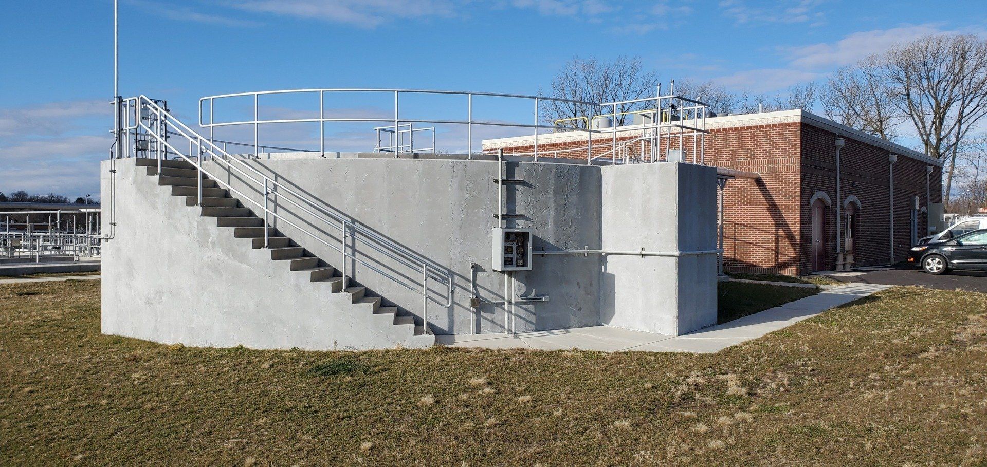 A building with stairs leading up to it and a car parked in front of it.