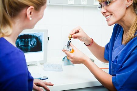 Dentist showing patient dental implants
