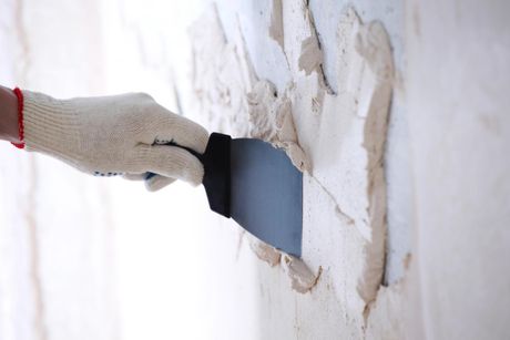 someone putting plaster on wall