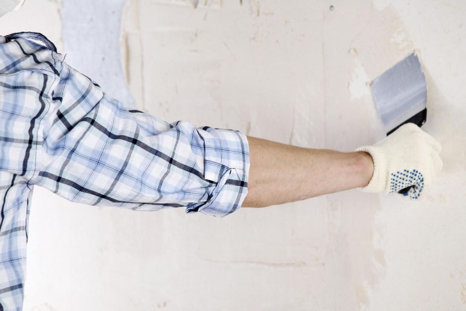 man installing plaster on the wall