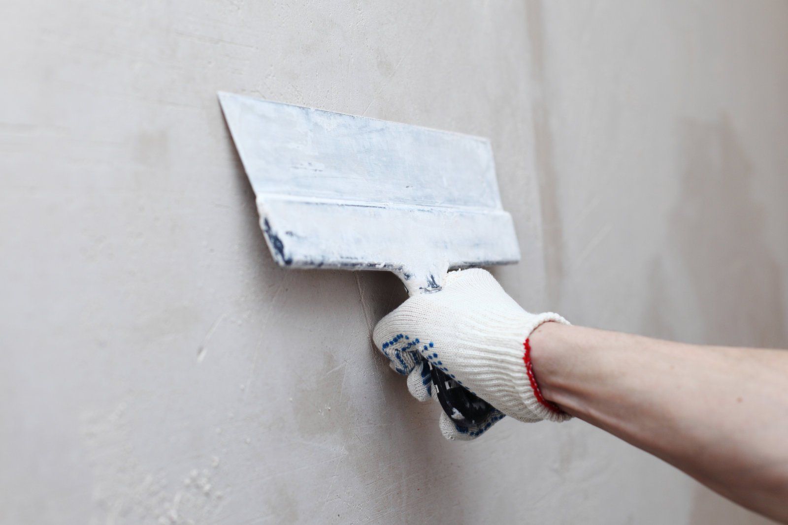 someone applying plaster on wall