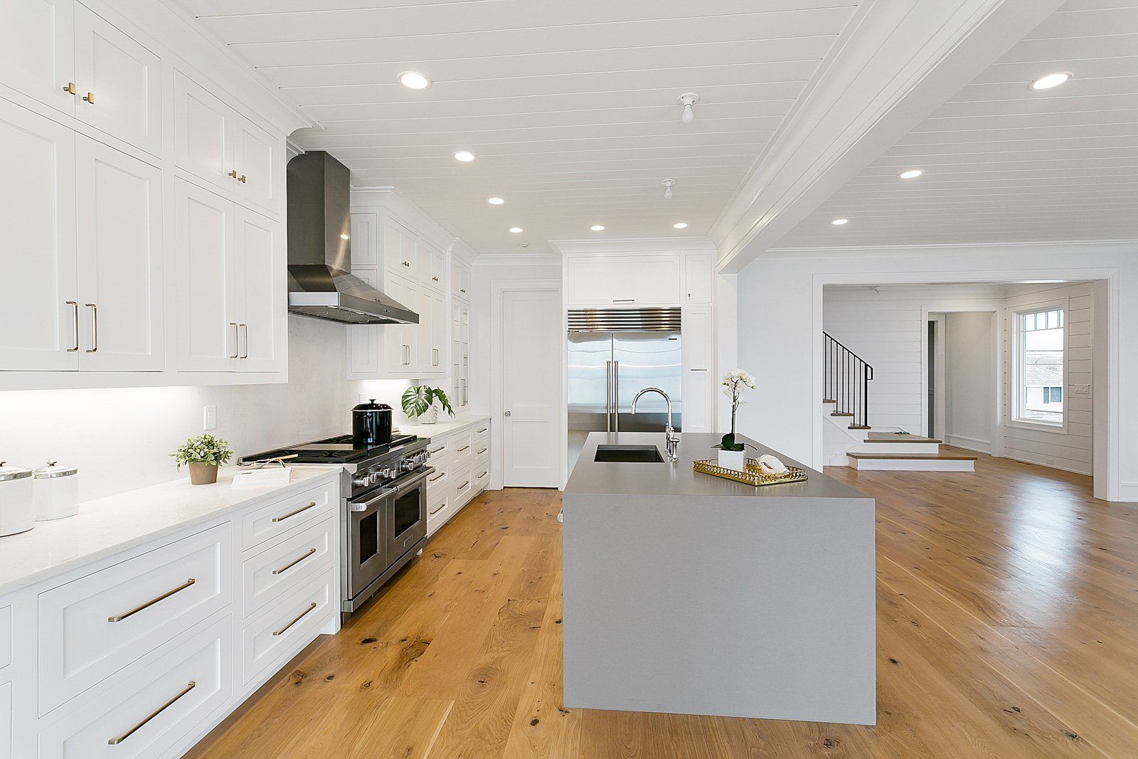 White Kitchen Cabinets, Gas Range & Waterfall Countertop