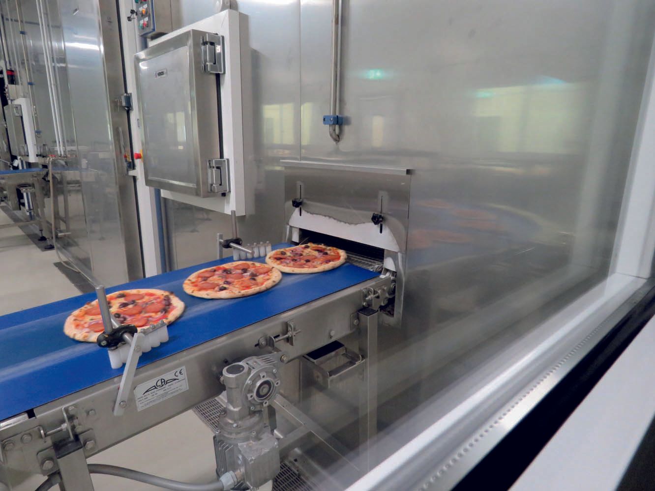 pizze surgelate sul nastro trasportatore di un abbattitore di temperatura
