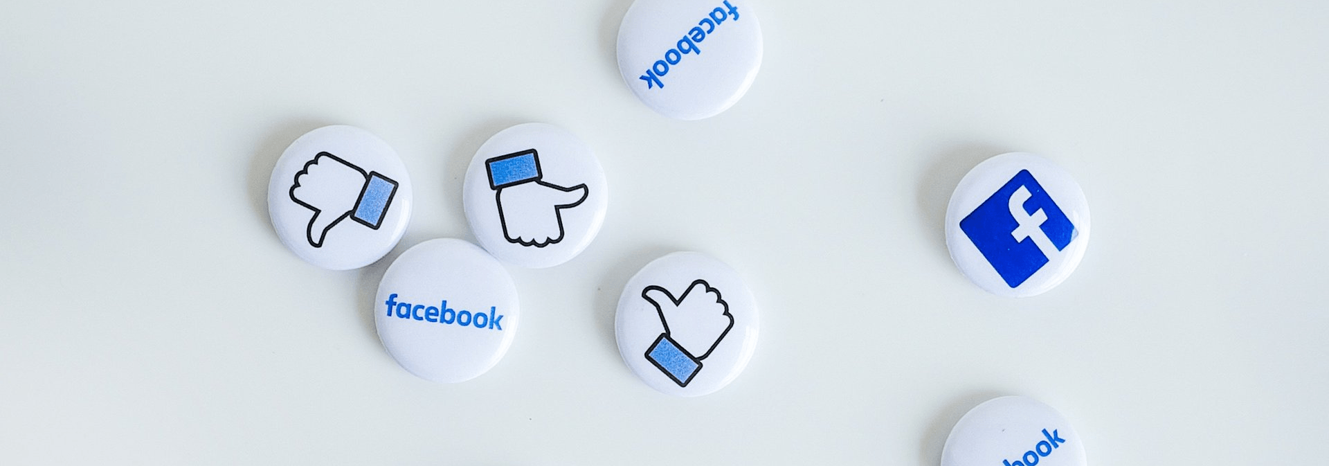 A bunch of facebook buttons are sitting on a white surface.