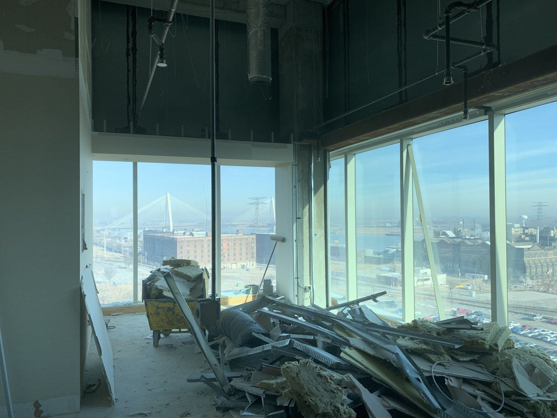 Damaged high-rise interior with rubble on the floor and city skyline visible through large windows