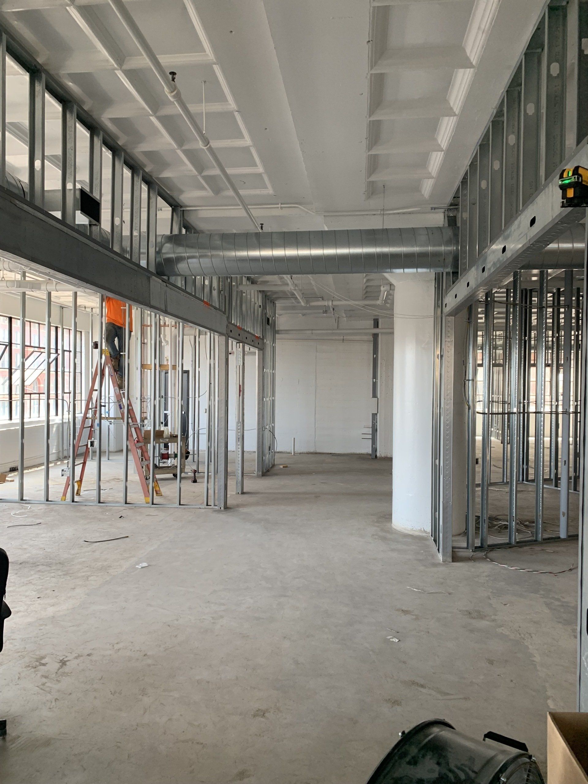 Unfinished interior of a commercial building with metal framing, exposed ceiling, and concrete floor