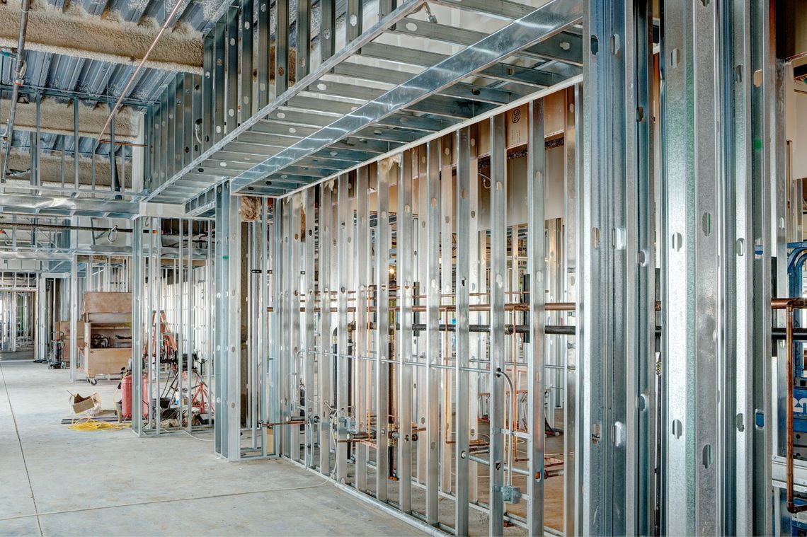 Interior of a building under construction with exposed metal framing and unfinished walls