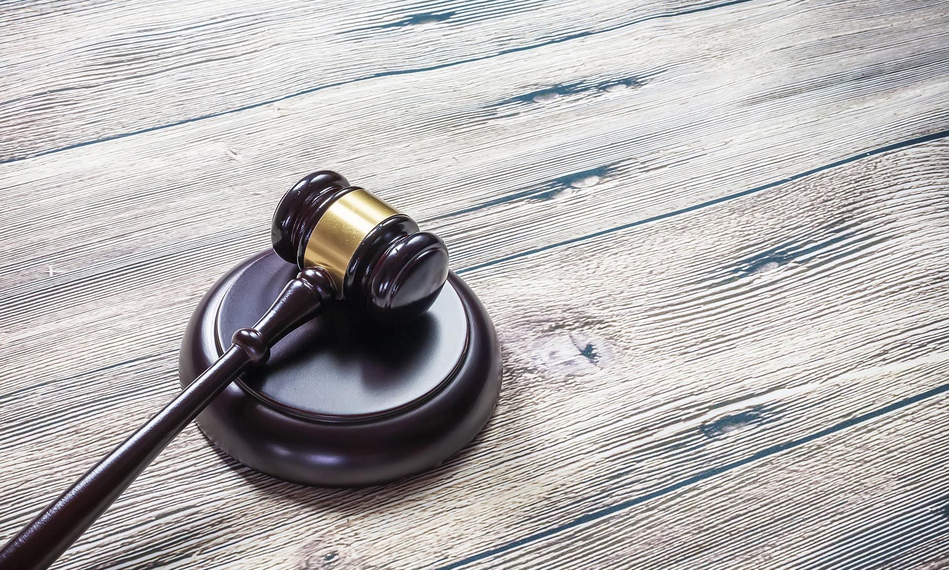 A judge's gavel is sitting on a wooden table.