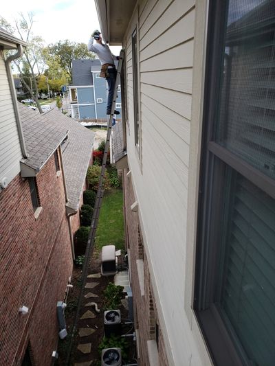 Man Drilling On Gutter — Aurora, IL — K&M Seamless Gutters