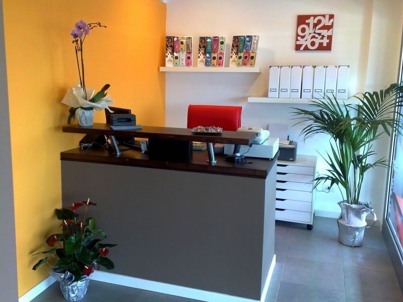 A modern, clean, and well-lit reception area of the centre, with plants and vibrant colours