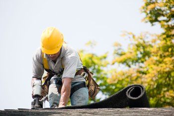 Construction worker working on roof — Construction in Quincy, IL Construction worker working on roof — Construction in Quincy, IL