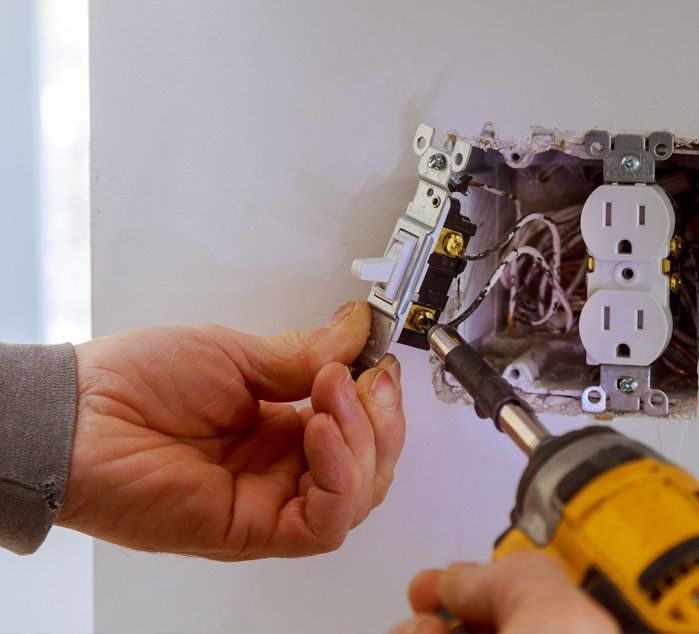 Hands Of An Electrician Installing A Power Switch — Norman, OK — Waters Electric Inc Hands Of An Electrician Installing A Power Switch — Norman, OK — Waters Electric Inc