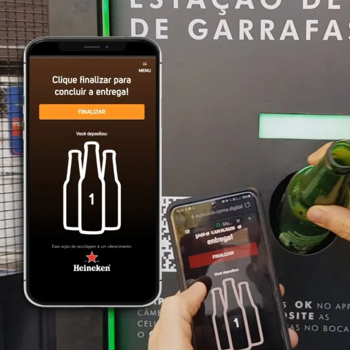 Uma pessoa segurando uma garrafa ao lado de um telefone que diz heineken