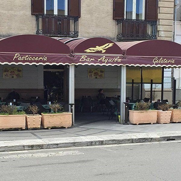 un tendone con scritto pasticceria bar Aquila gelateria