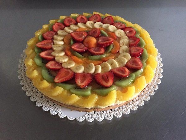 una crostata con delle fette di fragole, kiwi e ananas