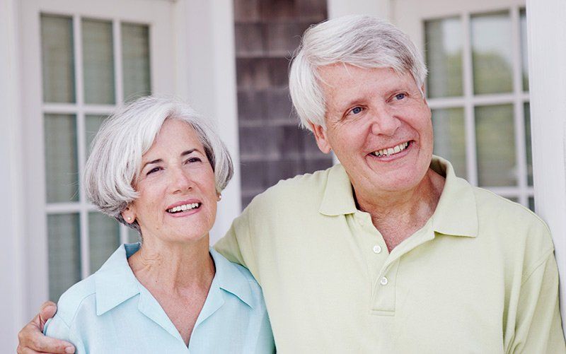 senior couple smiling and being affectionate outdoors