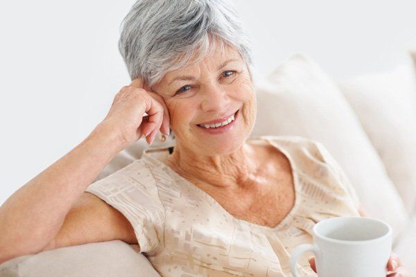 mandurah dental surgery dentures mature woman smiling with cup of coffee