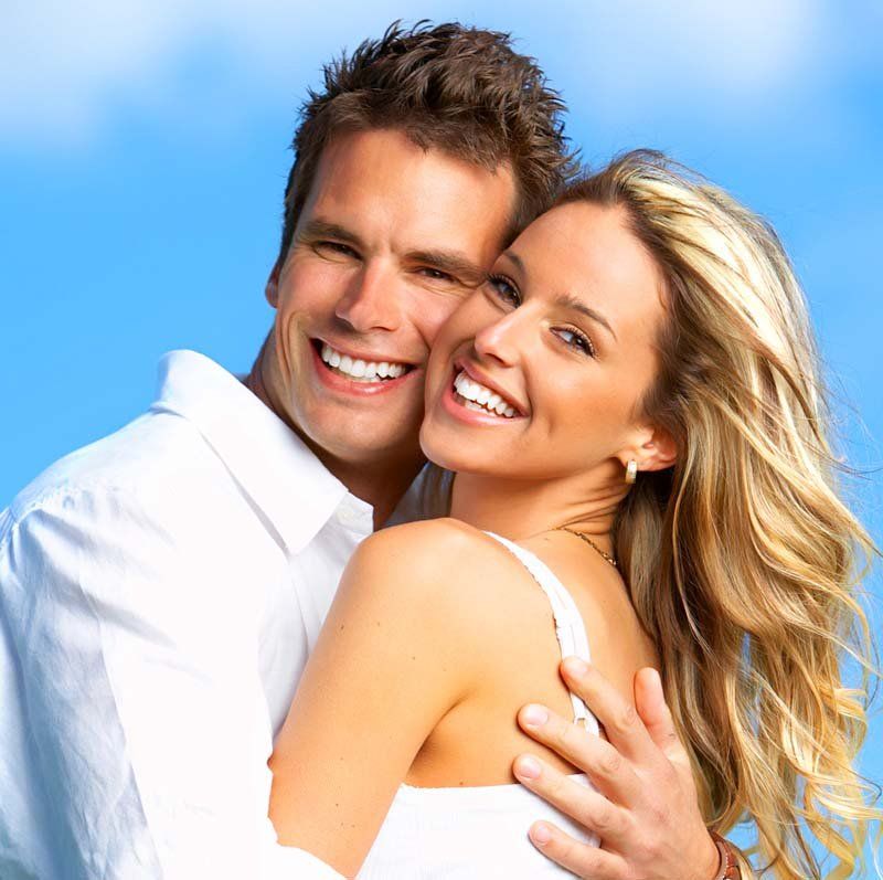 smiling couple young happy couple holding each other in sunlight