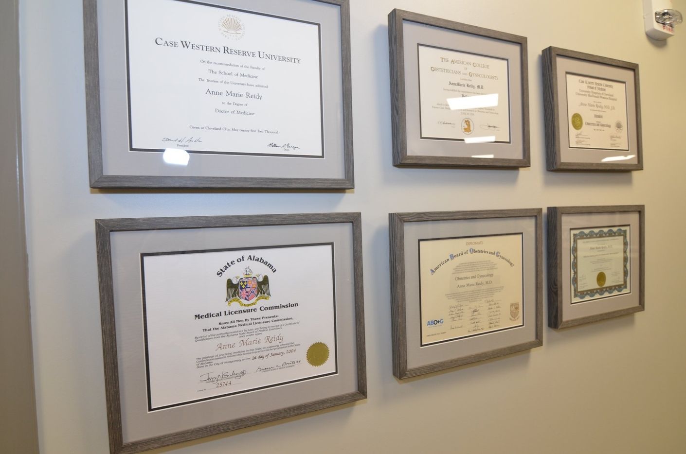 Several framed certificates are hanging on a wall