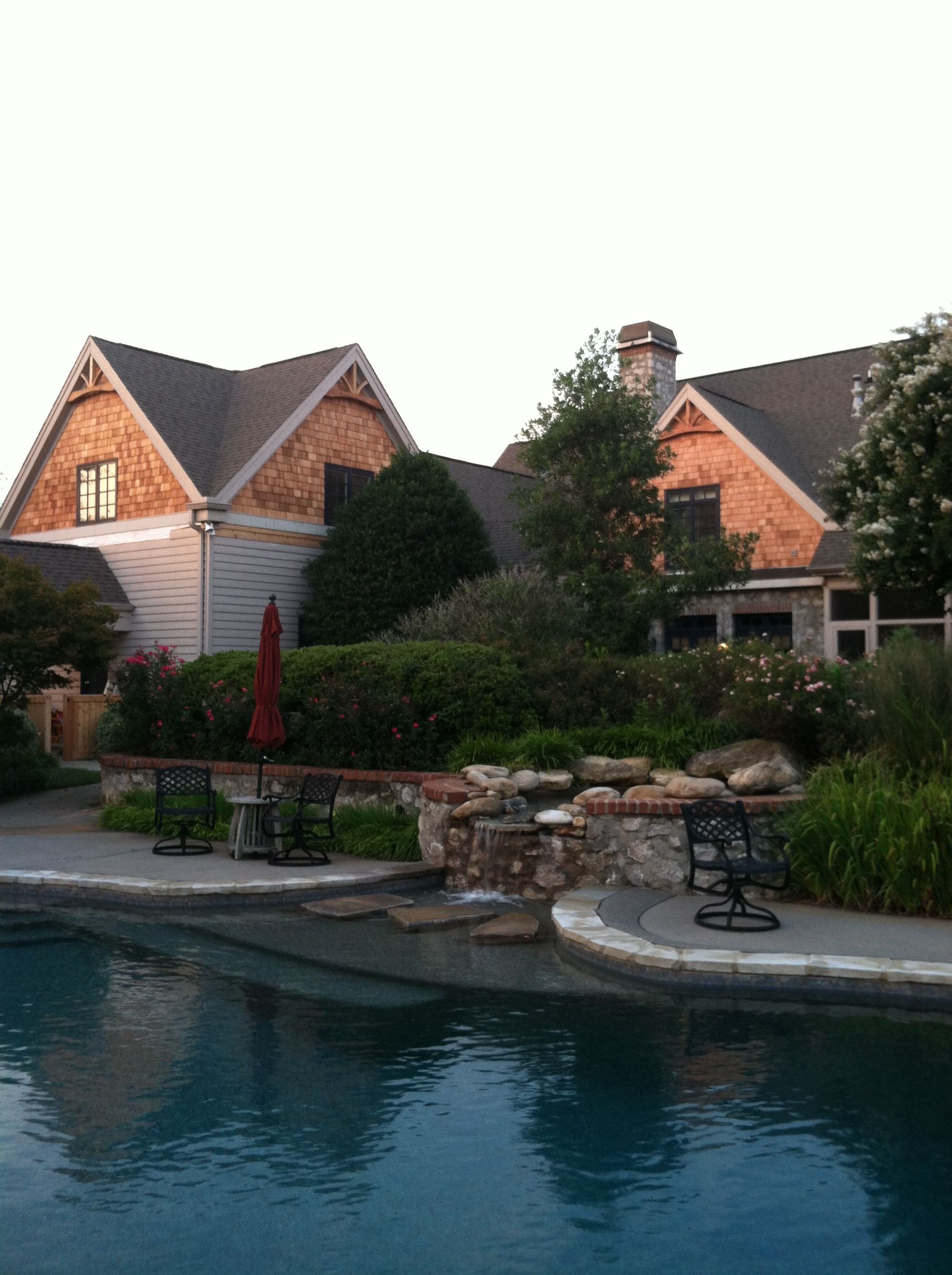 A large house with a swimming pool in front of it