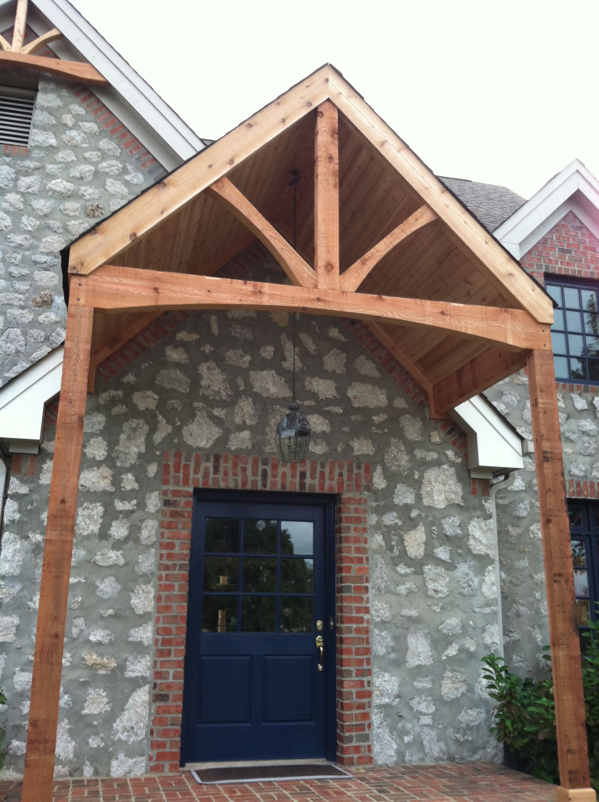 A stone building with a blue door and a wooden porch