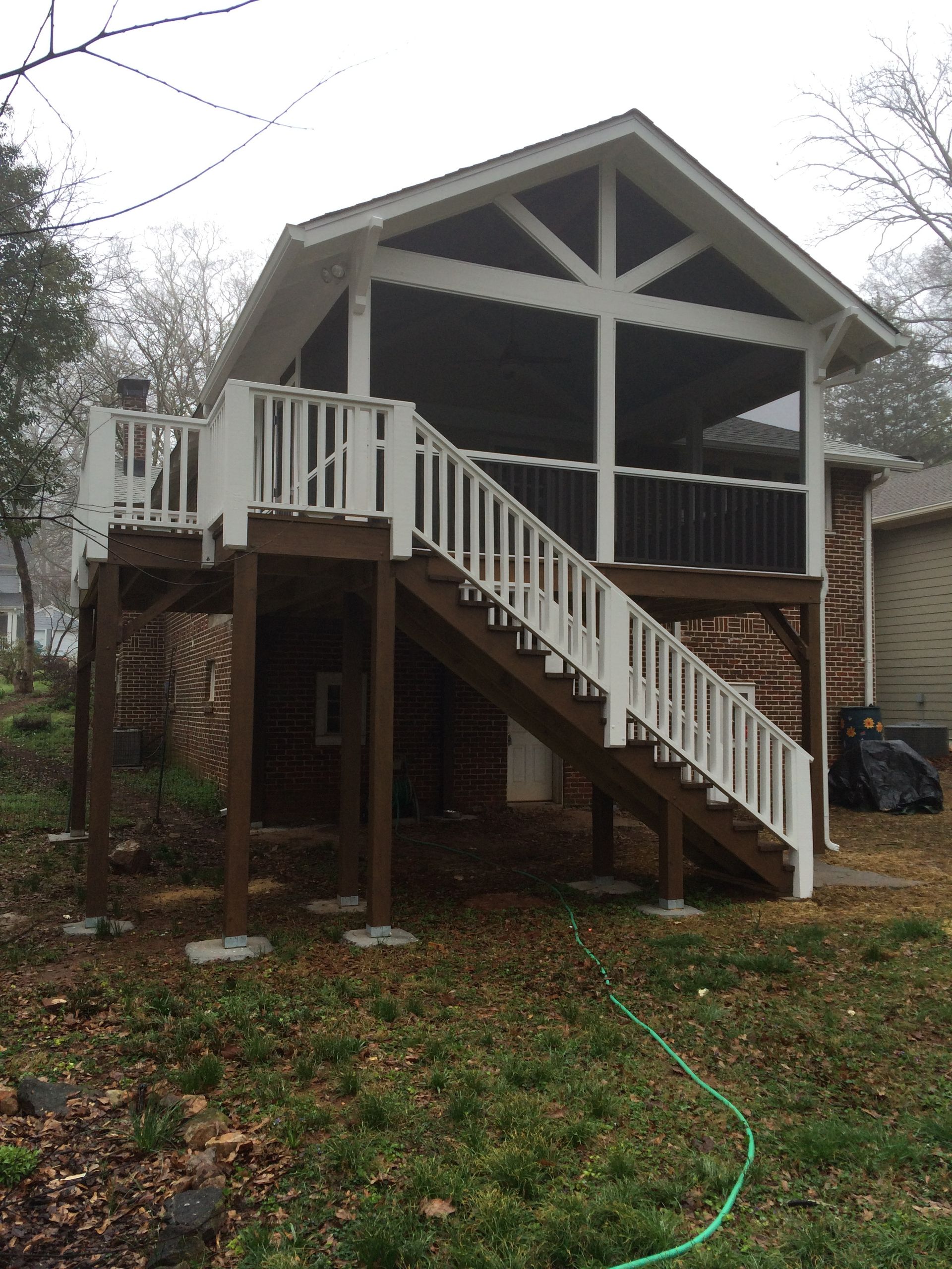 A screened in porch with stairs leading up to it