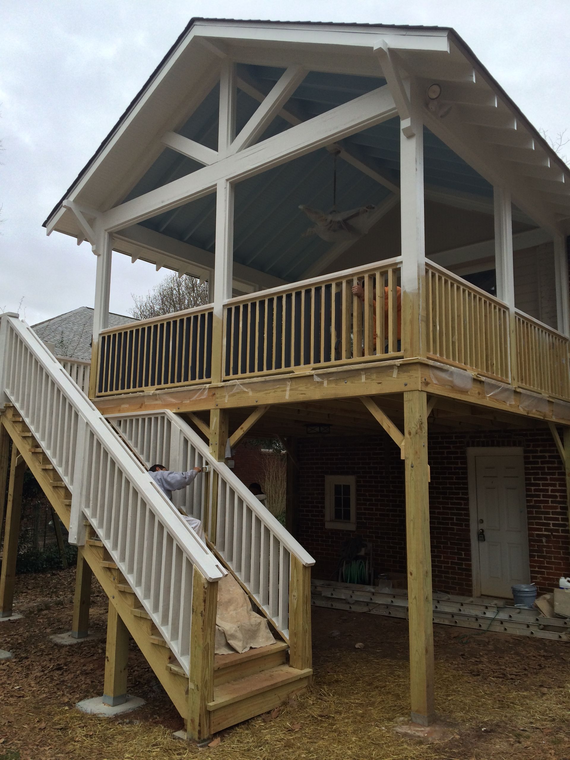 A house with a wooden deck and stairs leading up to it.